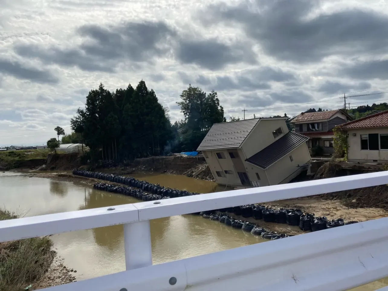 地震で傾いた家屋（橋の上より）